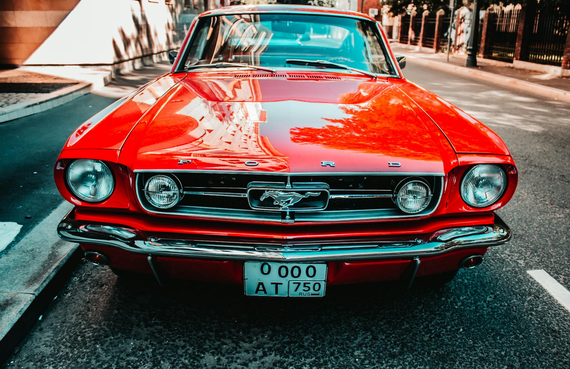 Czerwony klasyczny Ford Mustang zaparkowany przodem przy miejskiej ulicy