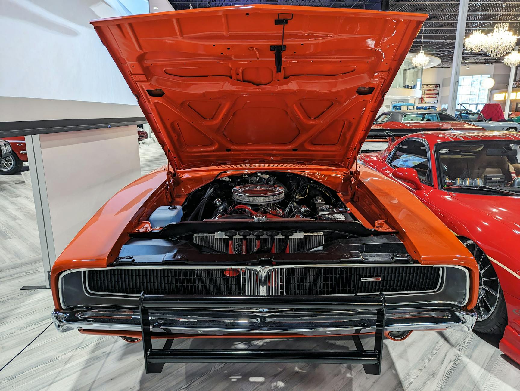Pomarańczowy klasyczny Dodge Charger z otwartą maską i widocznym silnikiem