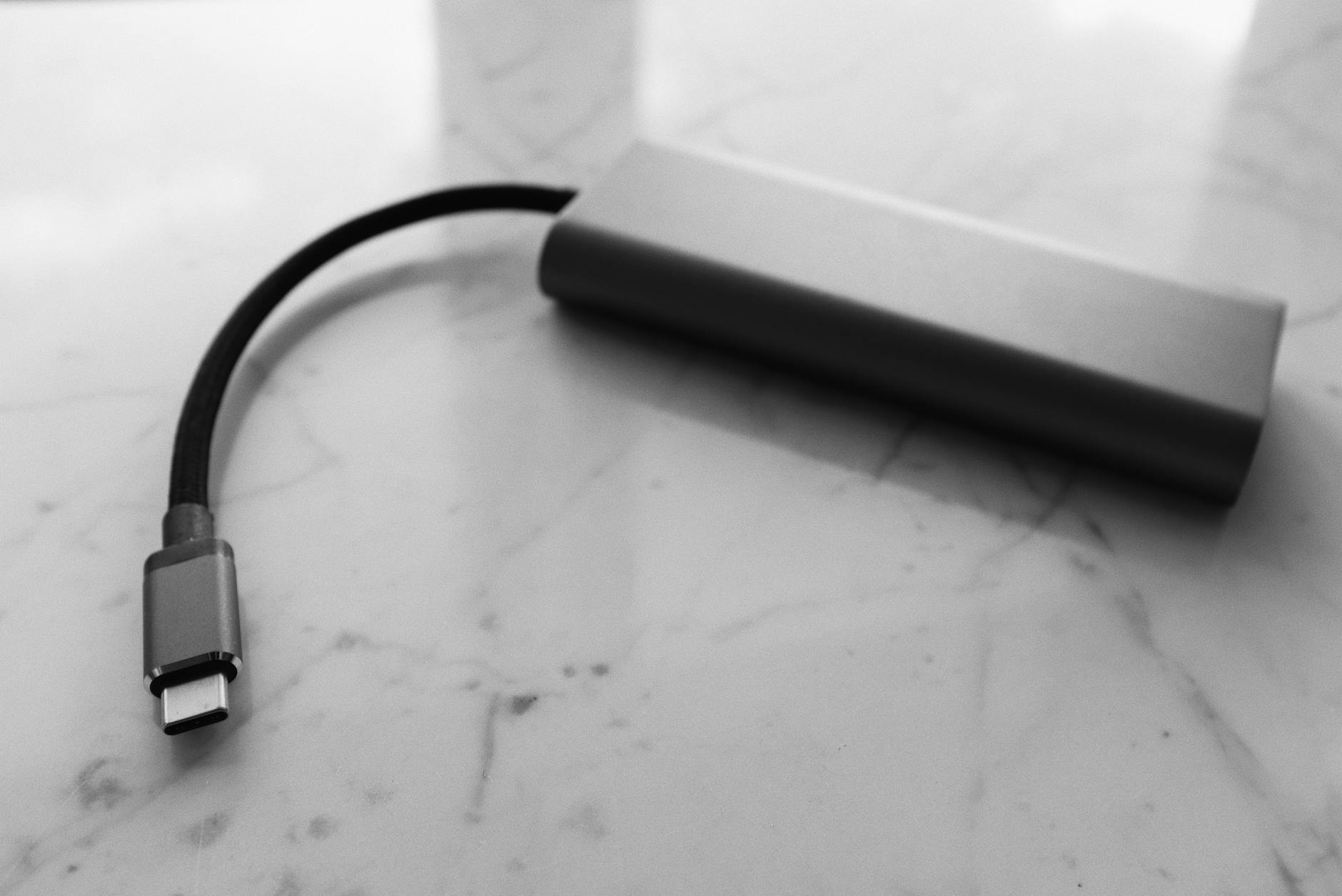 Czarny powerbank USB-C na białej, marmurowej powierzchni