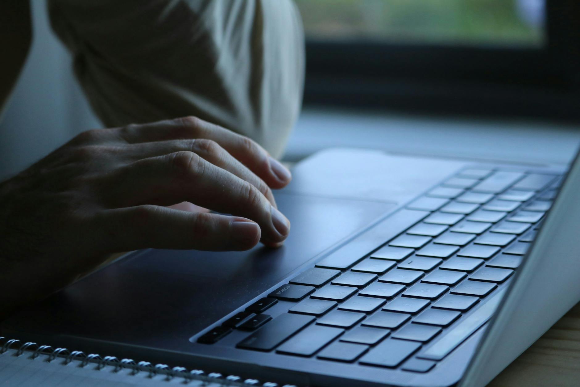 Dłonie piszące na klawiaturze laptopa podczas pracy z Windows 11