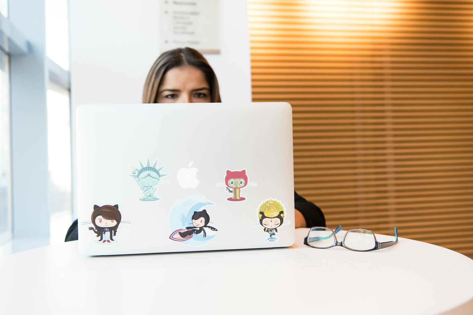 Kobieta programistka pracuje przy laptopie z naklejkami open source