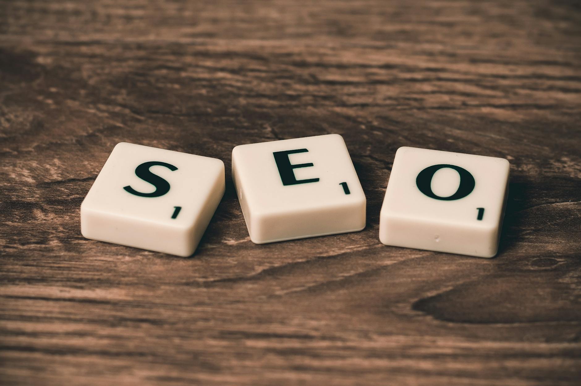 Kostki Scrabble układające się w napis SEO na drewnianym blacie