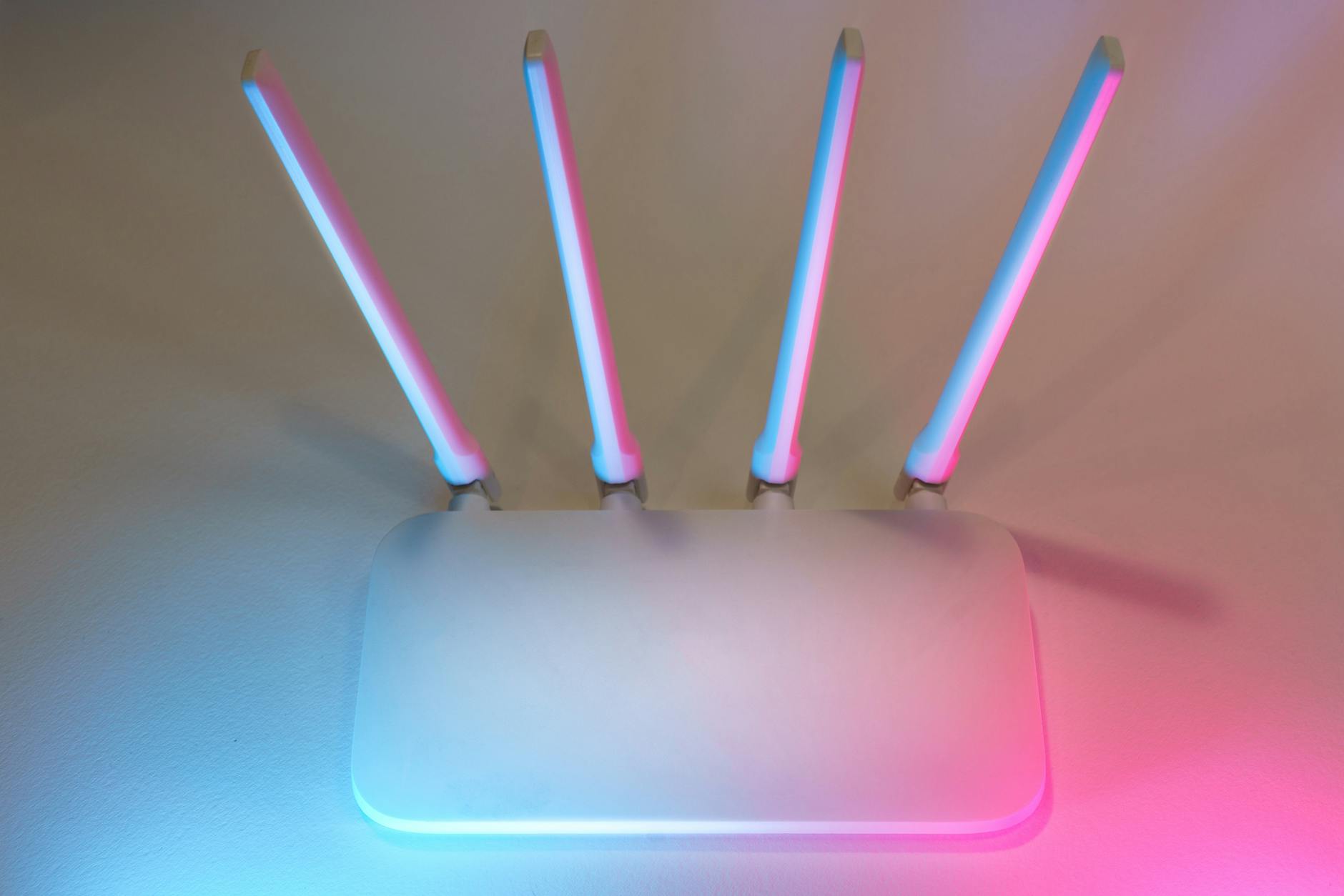 Biały router 5G z czterema antenami w niebiesko-różowym świetle