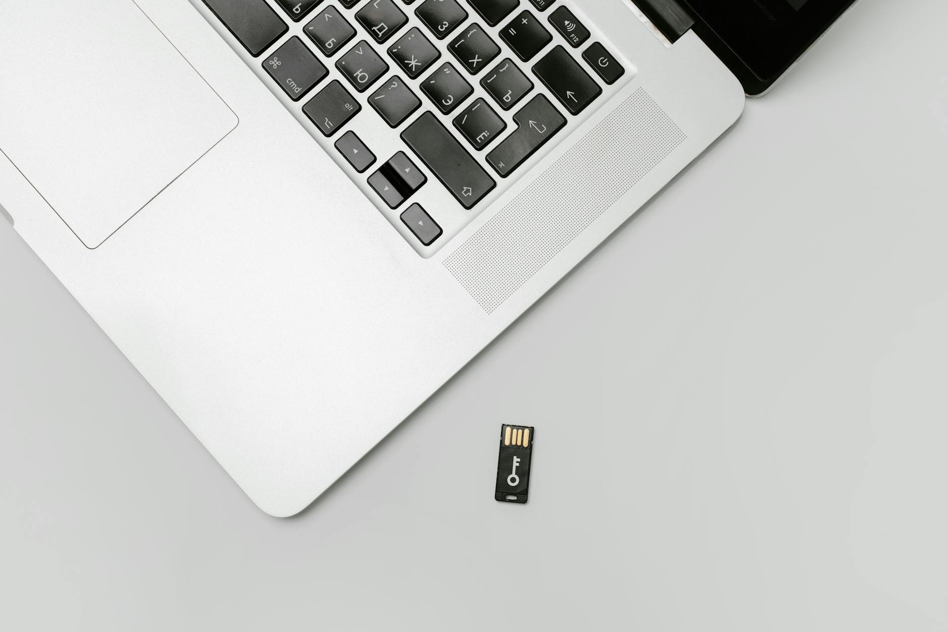 Laptop i pendrive na szarym tle jako podstawowy zestaw do szyfrowania