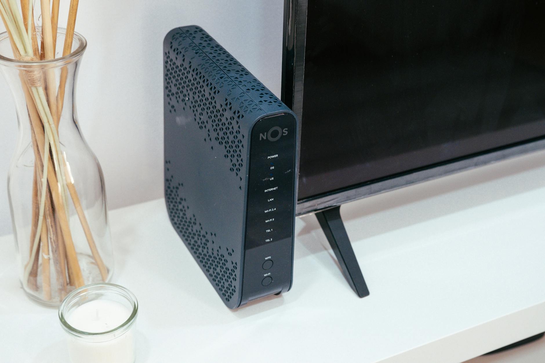 Nowoczesny router 5G w salonie obok telewizora i szklanej dekoracji