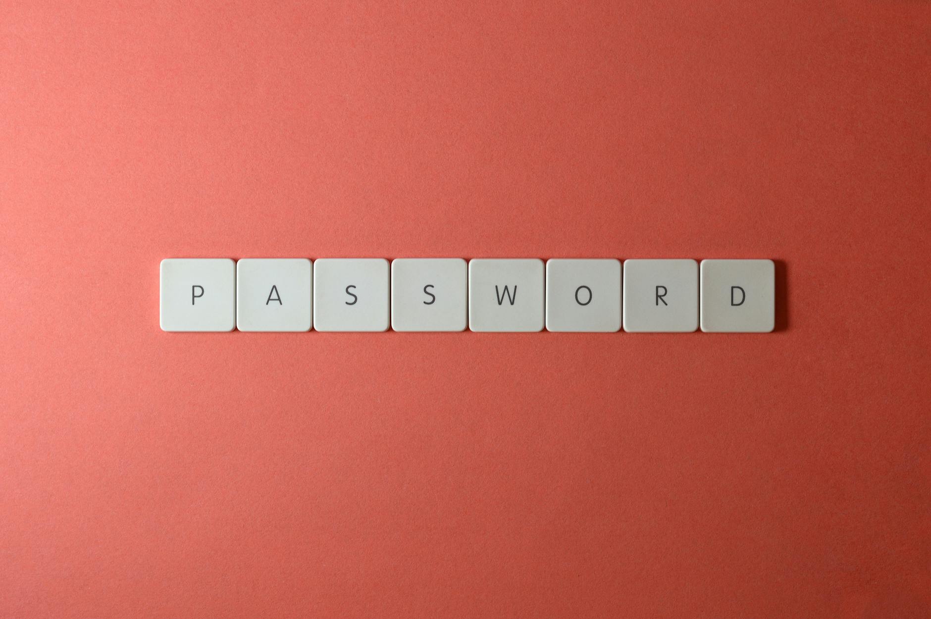 Białe klawisze klawiatury układające się w słowo PASSWORD na koralowym tle