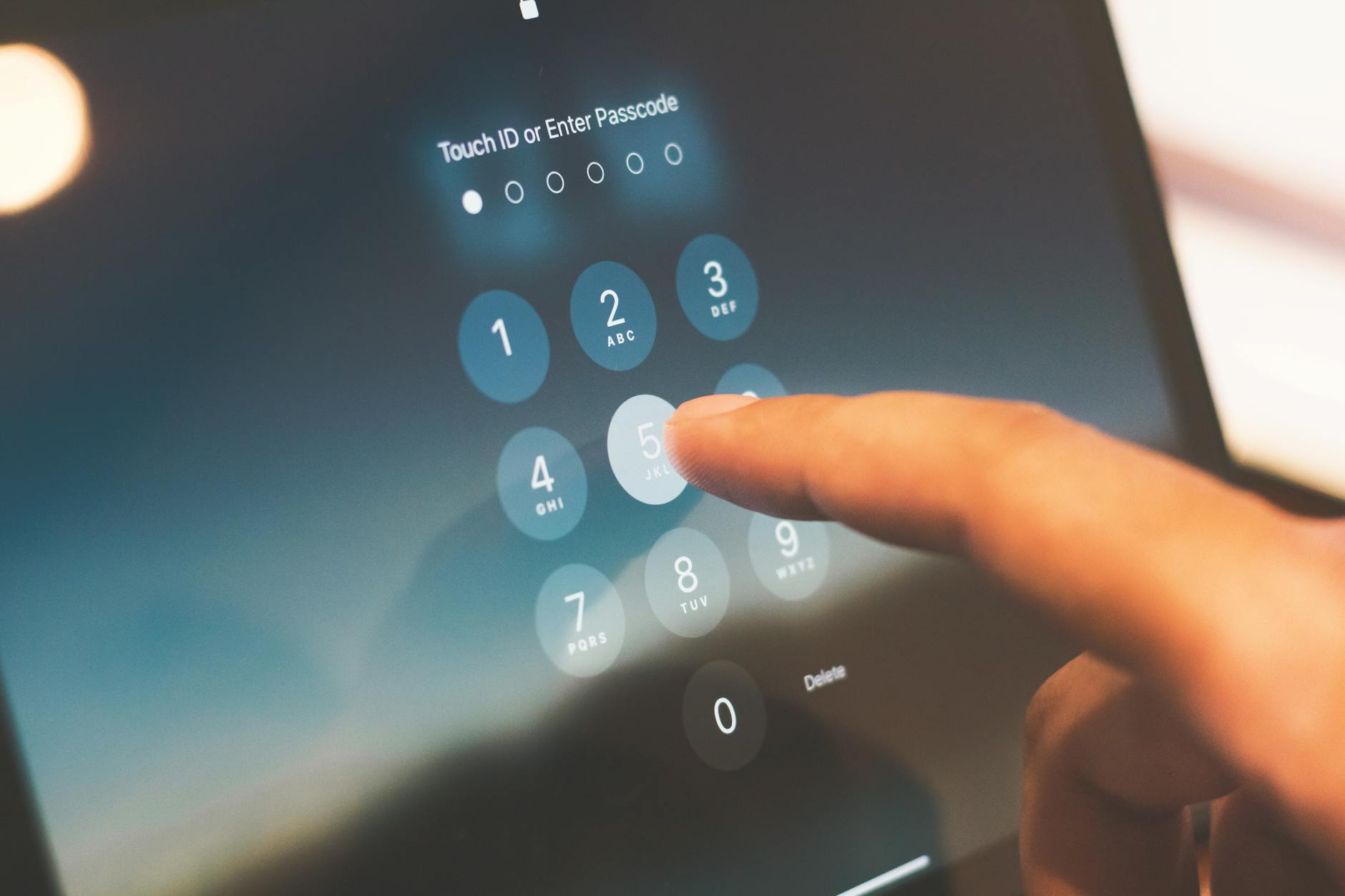 Palec wpisujący kod zabezpieczający na ekranie smartfona
