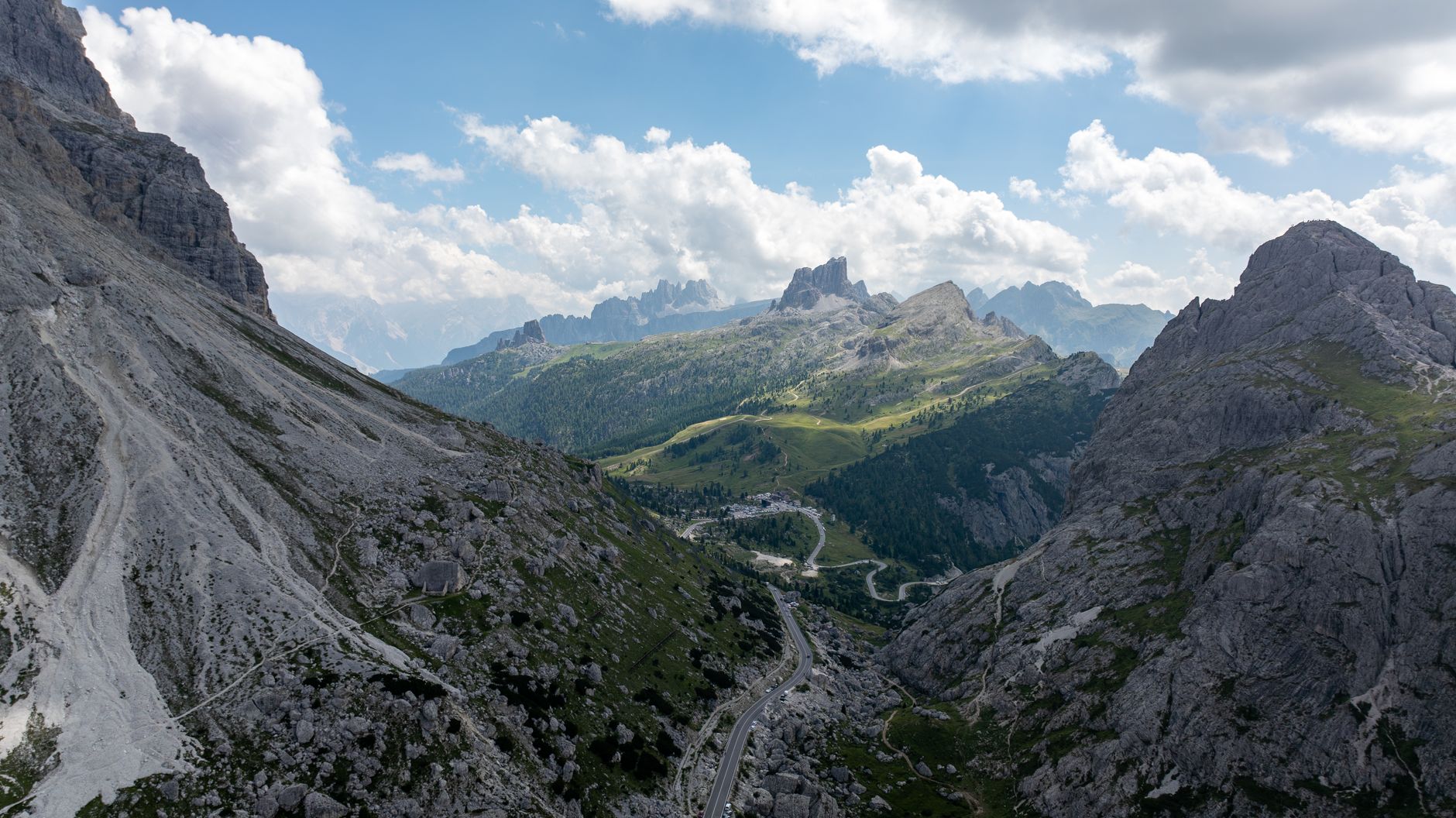 Kręta górska szosa wśród zielonych dolin włoskich Dolomitów