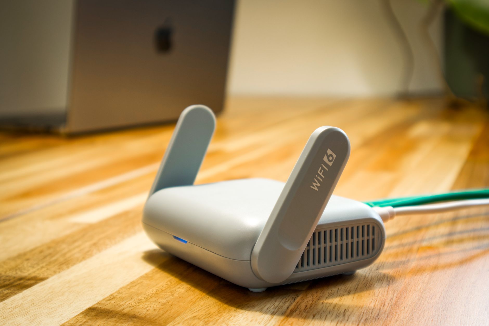 Router WiFi 6 z antenami i kablem na drewnianym biurku